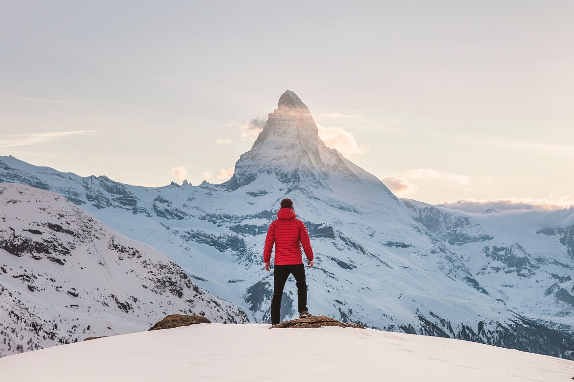 An explorer looking toward a snow-covered mountain peak